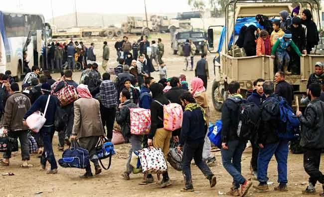Displaced Iraqi people who fled their homes during a battle between Iraqi forces and Islamic State militants, arrive at a checkpoint to be transfer to Hammam al-Alil camp, in Mosul, Iraq, on Monday. (Reuters)