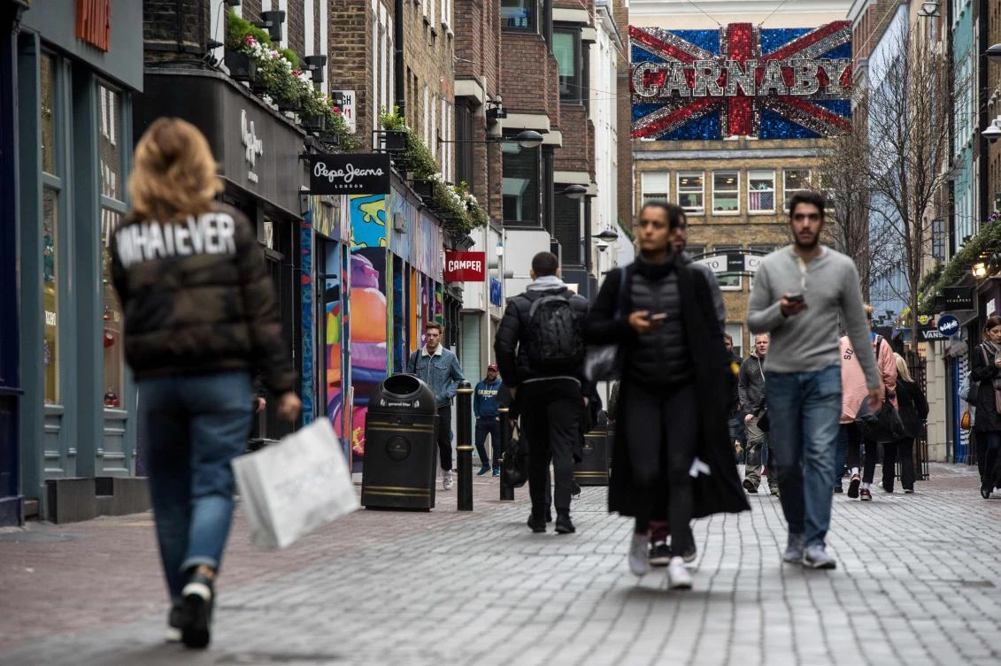 Pedestrians walk past retail outlets and shops on Carnaby Street in London. (AFP)