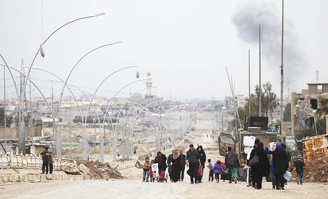 Iraqis displaced from the Nablous neighbourhood due to the ongoing fighting against Islamic State (IS) group fighters, flee to the Al-Sumoud neighbourhood on Wednesday, as an ongoing offensive by Iraqi forces to retake the city of Mosul from the jihadists continues. (AFP)