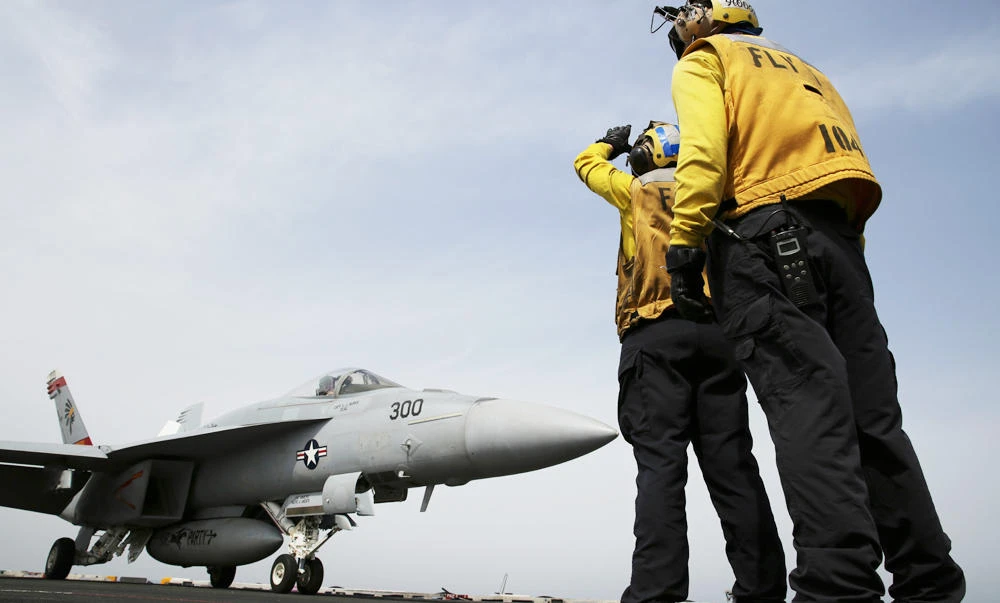 In this March 22, 2017 photograph, crew direct an F-18 on the USS George H.W. Bush as it travels through the Arabian Gulf. The carrier soon will begin launching airstrikes targeting the Daesh group in Iraq and Syria. (AP Photo/Jon Gambrell)