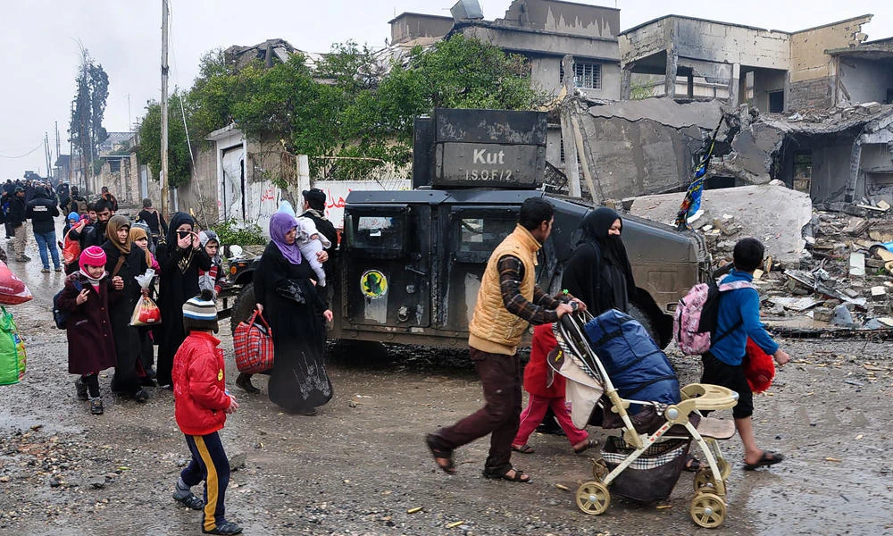 Iraqi civilians evacuate the area as the Iraqi counter-terrorism service (CTS) advance toward the Yabasat neighbourhood on March 23, 2017 during their ongoing offensive to push Daesh jihadists out of Mosul.(AFP / AHMAD AL-RUBAYE)