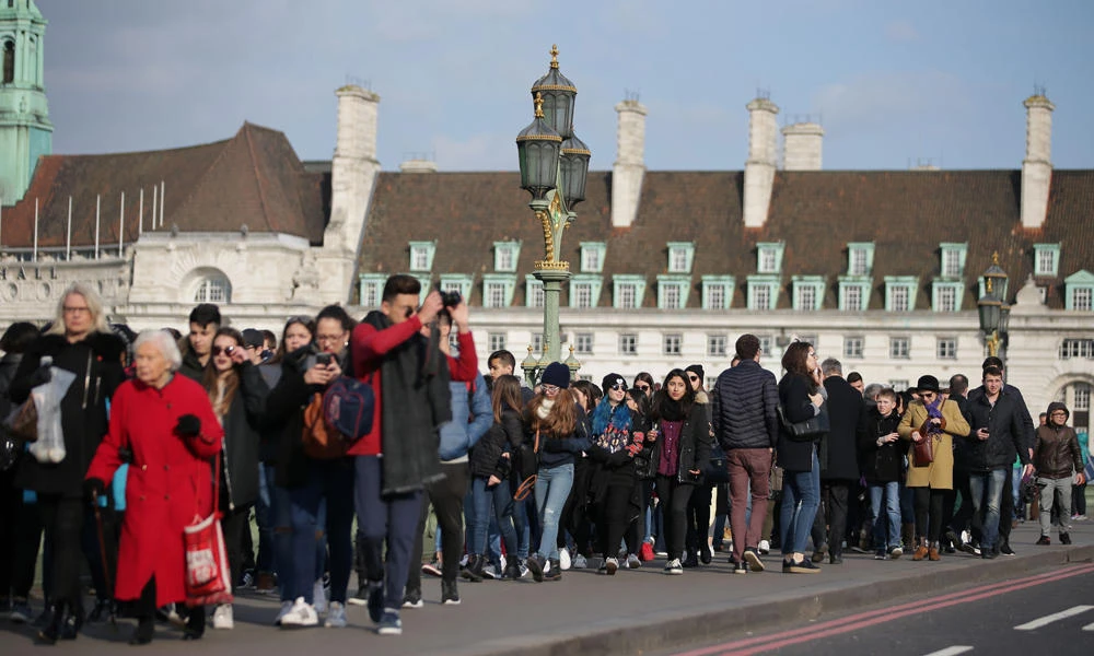 Members of the public walk along Westminster Bridge in central London on Thursday after it reopened following the March 22 terror attack at the British parliament. (AFP / Daniel Leal-Olivas)
