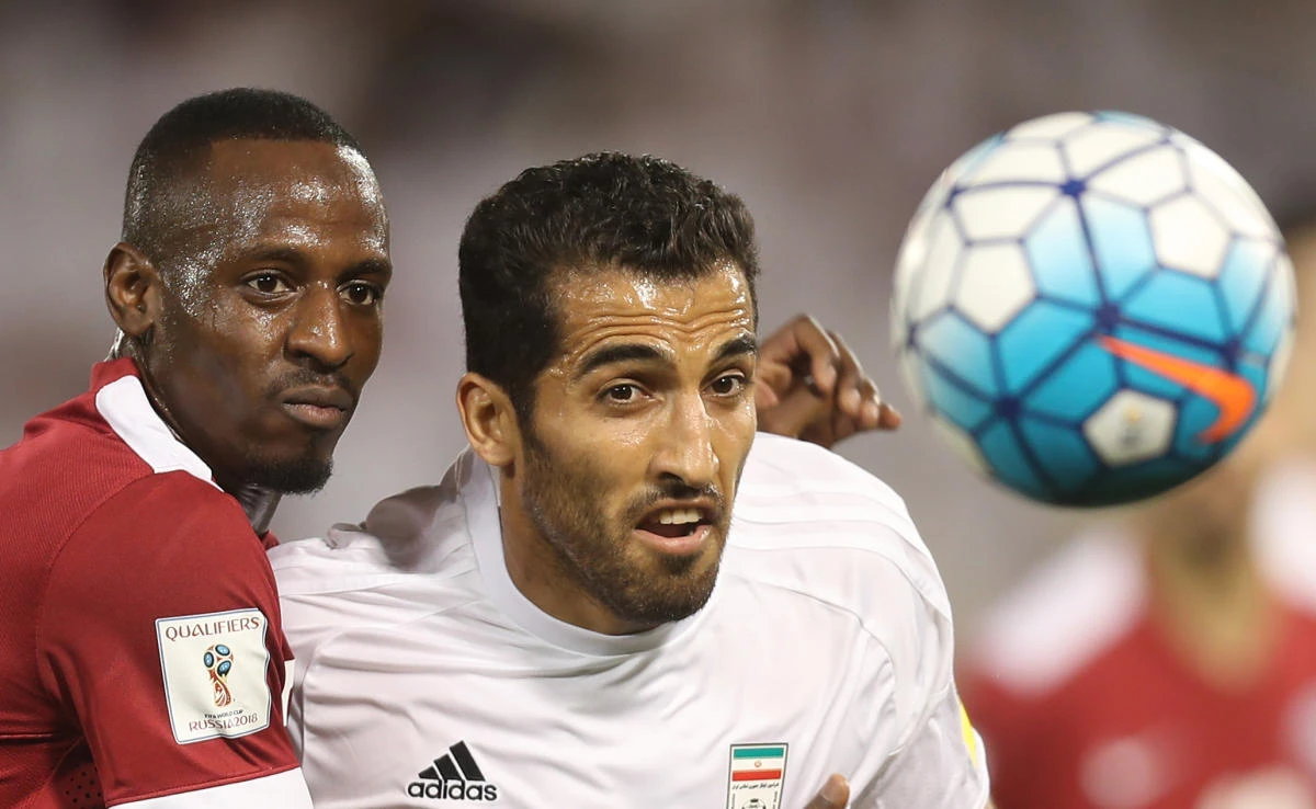 Iran's Vahid Amiri, right, and Qatar's Yasir Isa vie for the ball during the World Cup 2018 Asia qualifying football match at the Jassim Bin Hamad stadium in Doha on Thursday night. (AFP)