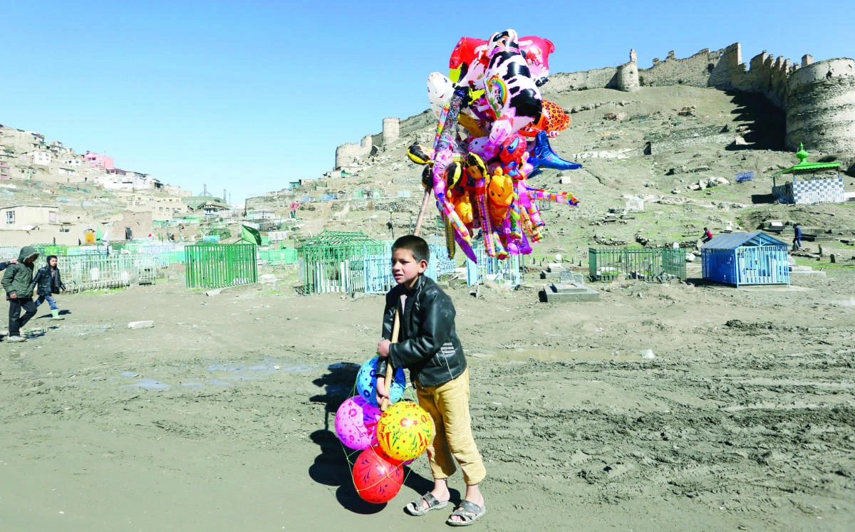 A young boy sells balloons in Kabul, on Thursday. An aid group said Thursday that nearly a third of all children in war-torn Afghanistan are unable to attend school, leaving them at increased risk of child labor and recruitment by armed groups. (AP)