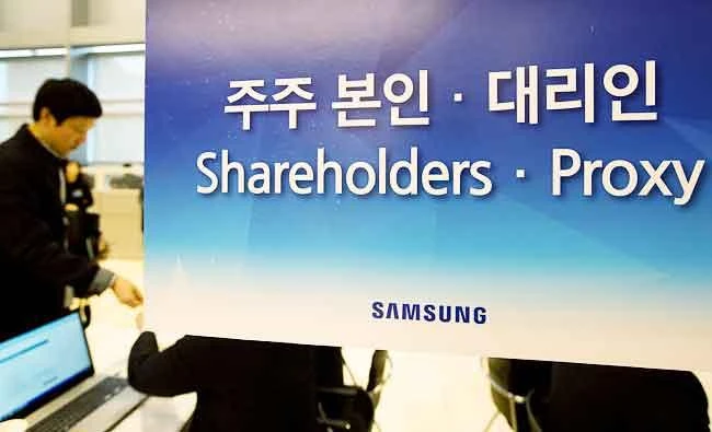 A shareholder stands behind a signage for the Samsung Electronics Co. annual general meeting at the company's Seocho office building in Seoul, South Korea, on Friday. (Reuters)