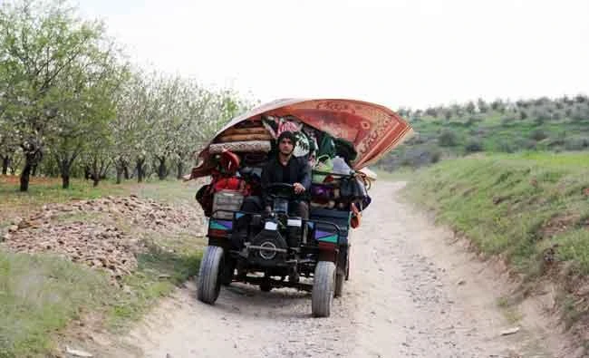 A Syrian man flees with his belongings from the village of Rahbet Khattab in the Hama province. The opposition has claimed more ground against Syrian regime forces in the province. (AFP)