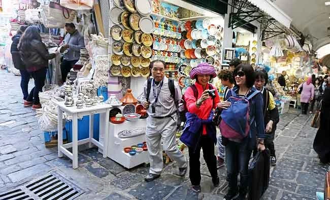 Vietnamese tourists walk past traditional souvenirs displayed for sale in the old city of Tunis, Tunisia, in this March 11, 2017 photo. (Reuters)