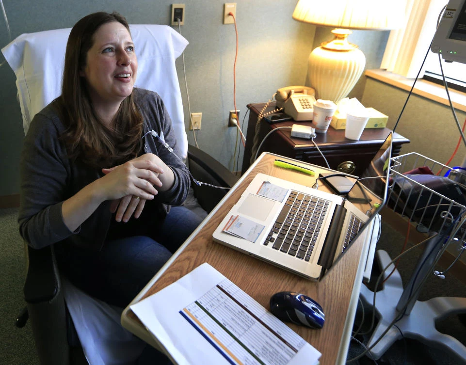 Janella Williams watches television for news on the health care vote while receiving treatment. (AP)