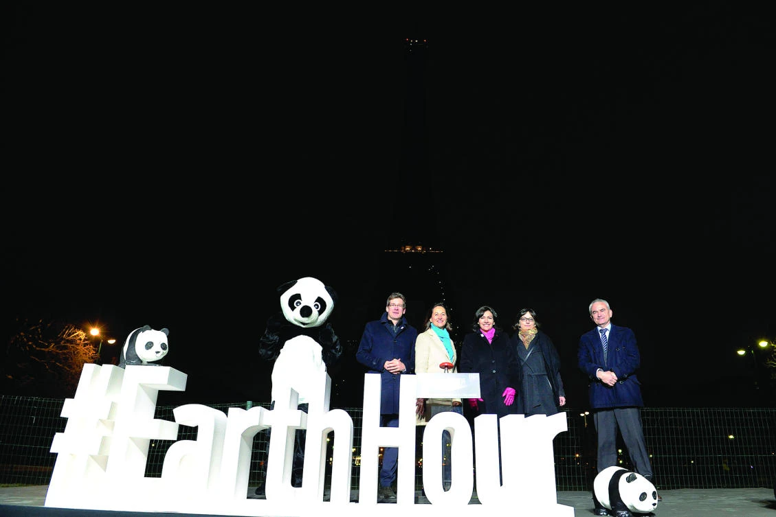 From left: WWF France President Pascal Canfin, French Ecology Minister Segolene Royal and Paris Mayor Anne Hidalgo near the Eiffel Tower in Paris after it went dark for the Earth Hour environmental campaign, in this file photo. (AFP)