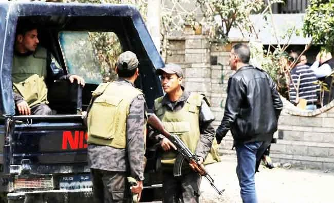 Riot police officers stand guard in front of the wall of a property's garden as security officials inspect the scene of an explosion, where the Interior Ministry said an unidentified metallic object was found, in the Cairo suburb of Maadi, Egypt, on Friday. (Reuters)