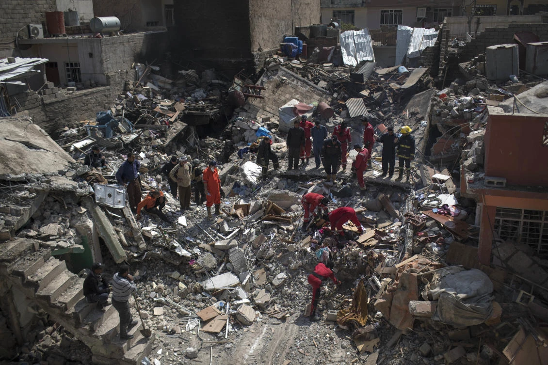 Civil protection rescue team work on the debris of a destroyed house to recover the body of people killed during fights between Iraq security forces and Islamic State on the western side of Mosul, Iraq. (AF)