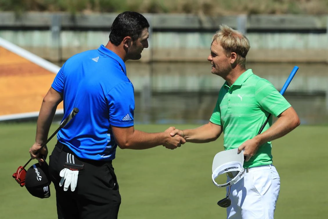 Jon Rahm, left, of Spain, shakes hands with Soren Kjeldsen, of Denmark, after winning their match 7 and 5 on the 13th hole during round five of the World Golf Championships-Dell Technologies Match Play at the Austin Country Club on Saturday in Austin, Texas. (AFP)