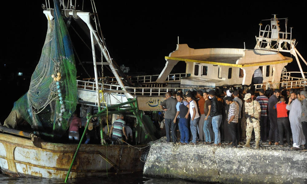 This file photo taken on September 28, 2016 shows people gathering on the quay as a wreck of a migrant boat raised by the Egyptian navy and maritime rescuers arrives in the Egyptian port city of Rosetta. ( AFP file photo)