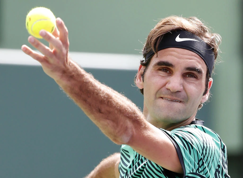 Roger Federer, of Switzerland, tosses the ball to serve to Frances Tiafoe during a tennis match at the Miami Open Saturday in Key Biscayne, Fla. (AP)