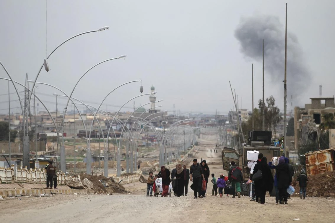Iraqis displaced from the Nablous neighborhood due to the ongoing fighting against Daesh fighters, flee to the Al-Sumoud neighborhood on March 22, 2017, as an ongoing offensive by Iraqi forces to retake the city of Mosul from the jihadists continues. (AFP)