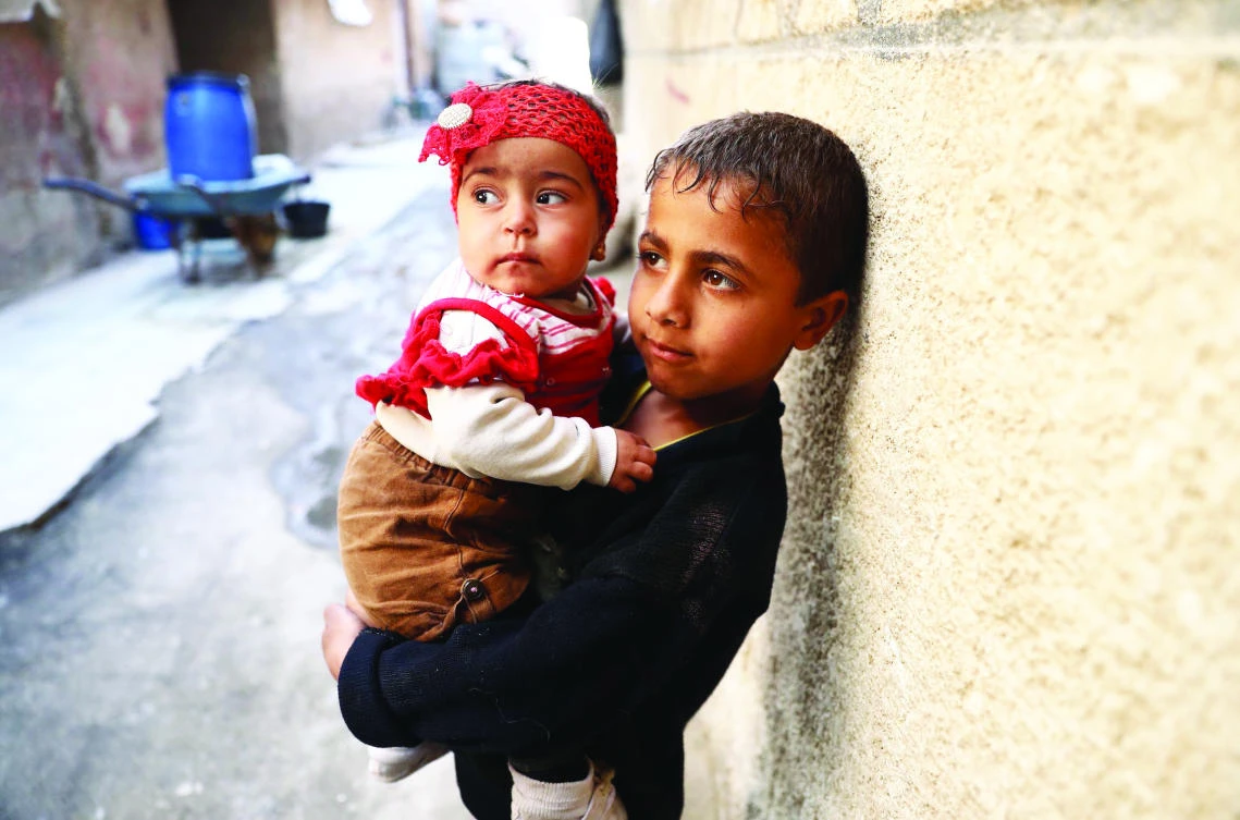 A Syrian boy carries a child in the eastern Ghouta region
on the outskirts of Damascus. (AFP)