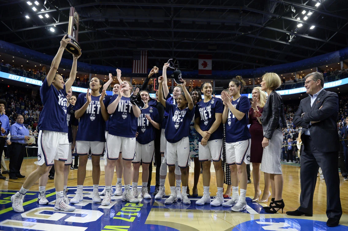Connecticut’s Saniya Chong holds the trophy as her teammates cheer following their win over Oregon in a regional final game in the NCAA women's college basketball tournament, in Bridgeport, on Monday. (AP)