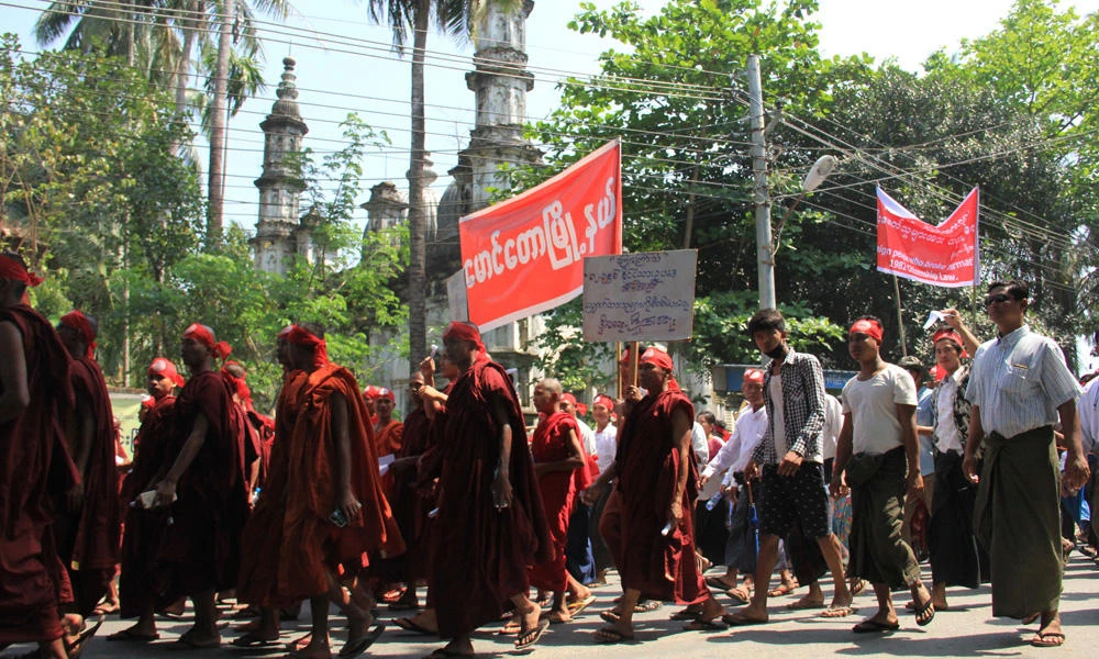 Hard-line Buddhists including monks walk by a mosque during a protest march against the government's plan to give citizenship to some members of the persecuted Rohingya Muslim minority community in Sittwe, Rakhine state, Myanmar, on March 19, 2017. An armed militant group fighting Myanmar’s government on behalf of the country’s Muslim Rohingya minority has issued a statement asserting its right to self-defense and denying links to any terrorist group. (AP Photo/Esther Htusan)