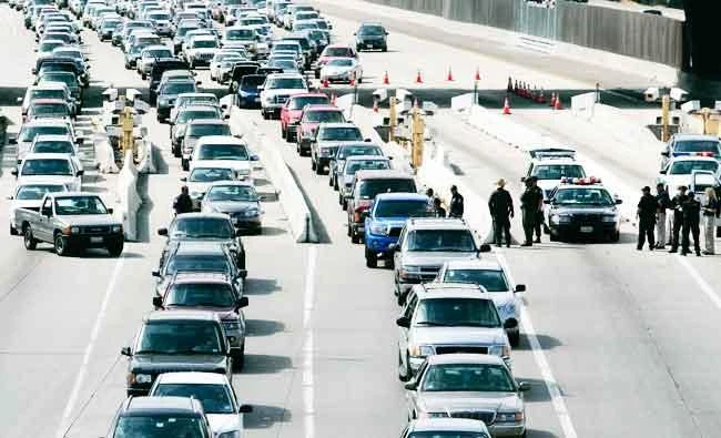 In this April 23, 2009 file photo, U.S. border officials set-up a road block to search cars as traffic backs up on Interstate-5 before crossing the border into Mexico from the U.S. at the San Ysidro Port of Entry in San Diego. (AP)
