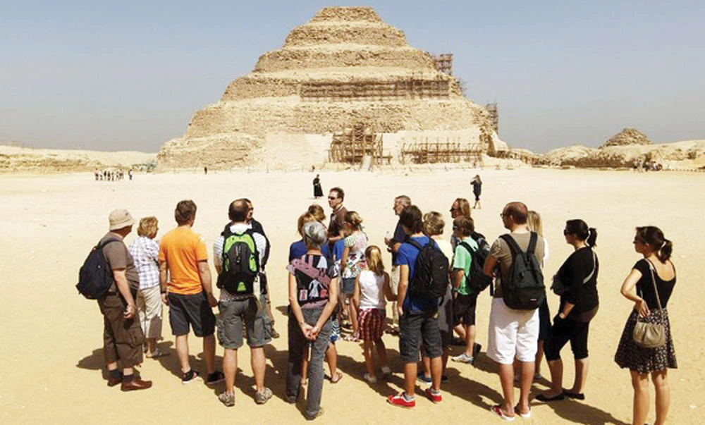 Tourists listen to a guide near the Djoser’s step pyramid in Saqqara, outside of Cairo. (Reuters)