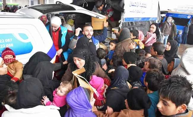 Syrians who fled from rebel-held areas in east Aleppo receive aid food on December 1, 2016, at a warehouse in Duweirineh, a small village on the eastern outskirts of the embattled city. (AFP)