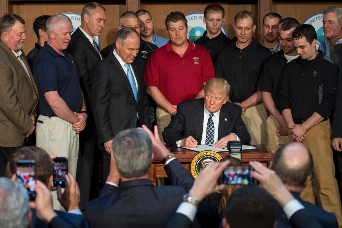 Surrounded by miners from Rosebud Mining, US President Donald Trump (C) signs he Energy Independence Executive Order. (AFP)