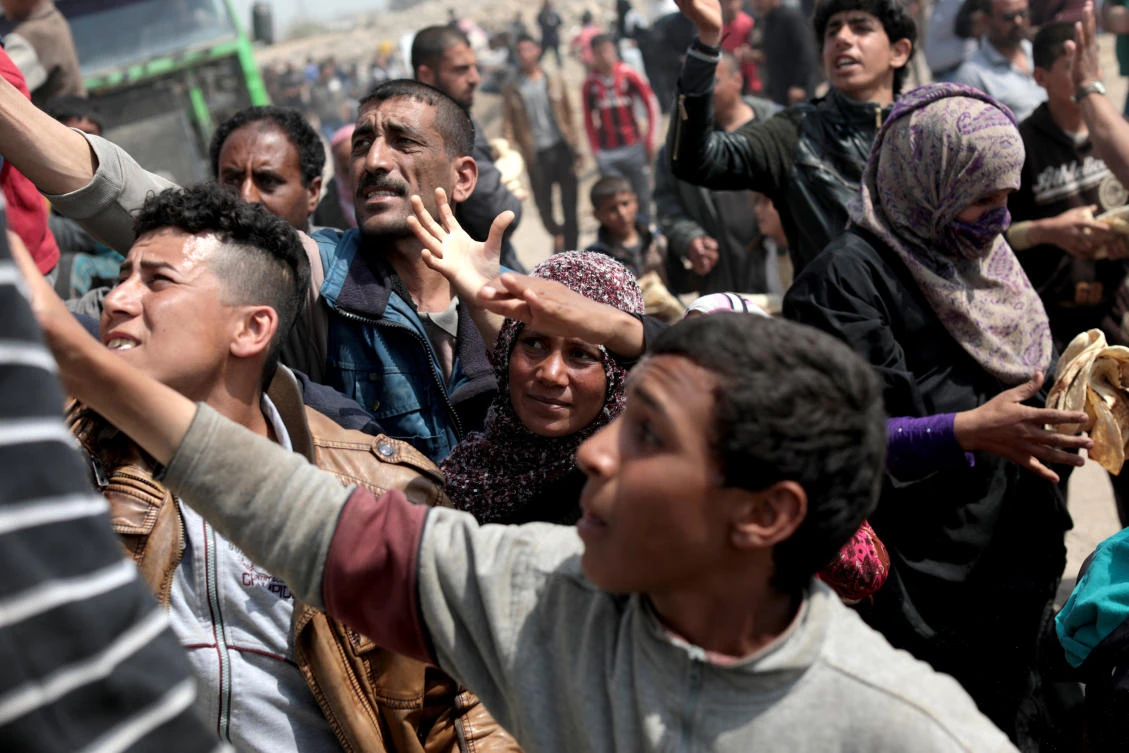 Displaced Iraqis try to get food during a delivery outside of Hammam al-Alil camp in the south of Mosul, Iraq. (Reuters)