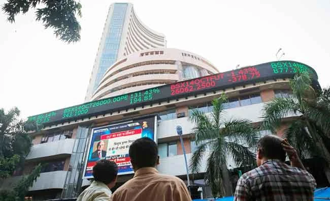 People watch a large screen displaying India's benchmark share index on the facade of the Bombay Stock Exchange (BSE) building in Mumbai, in this October 16, 2014 file photo. (Reuters)