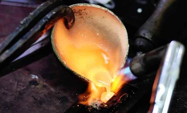 In this photo taken on March 22, 2017 an Indonesian goldsmith pours liquid gold into a mold at his workshop in Jakarta. (AFP)