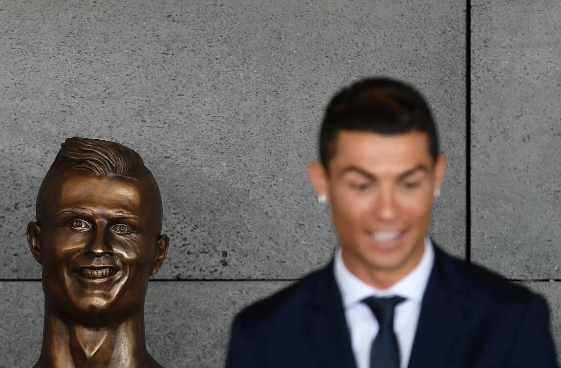 Portuguese footballer Cristiano Ronaldo stands beside a bust presented during a ceremony to rename Madeira’s airport in Funchal as “Cristiano Ronaldo,” on Madeira island, on March 29, 2017. (AFP)