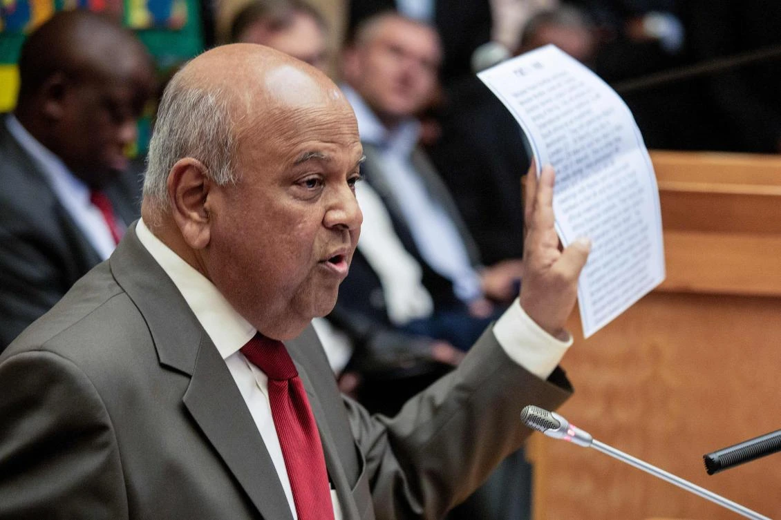 South African former Finance Minister Pravin Gordhan holds an alleged intelligence report as he addressed media. (AFP)