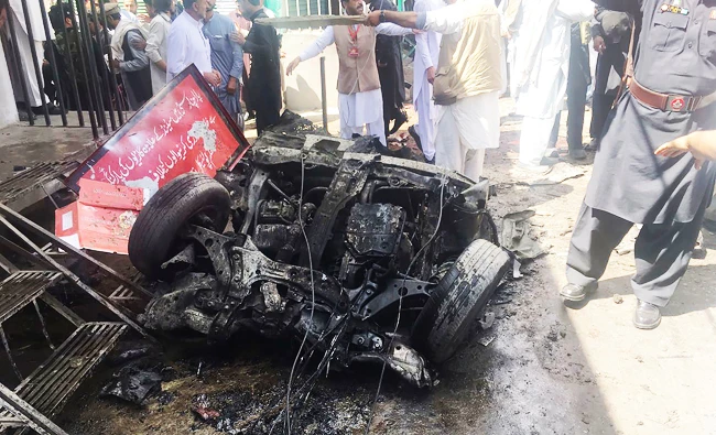 Pakistani security officials and residents gather at the site of a powerful explosion at a market in Parachinar. (AFP)