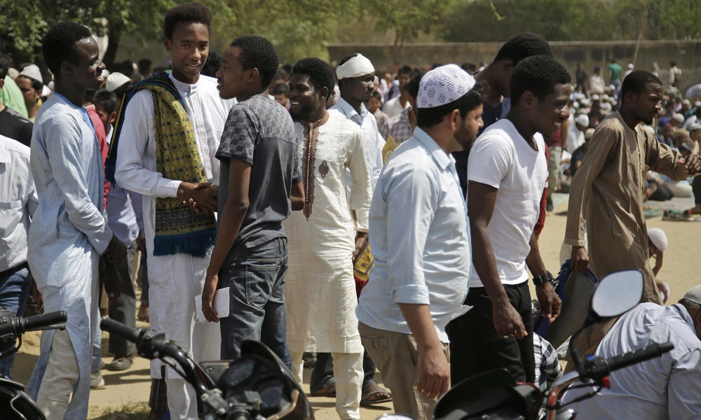 In this March 30, 2017 photo, African students greet each other after Friday prayers in Greater Noida, India. Tens of thousands of Africans live and study in India, and newly built suburbs like Greater Noida especially draw students because they are home to several sprawling private universities. But prejudice and racism are near-constants for Africans in the country. (AP Photo/Altaf Qadri)