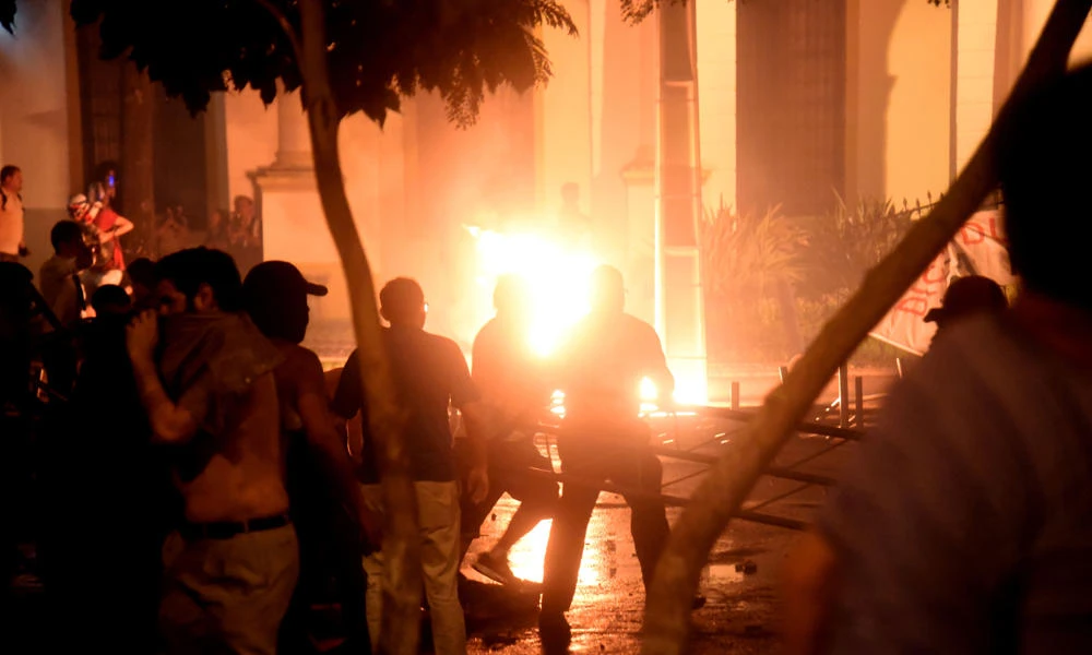 Hundreds of demonstrators protesting against the approval of a constitutional amendment for presidential reelection broke into the Congress building in Asuncion on Friday, battering down entrances and fences and shattering windows, and started to set fires inside. (AFP / NORBERTO DUARTE)