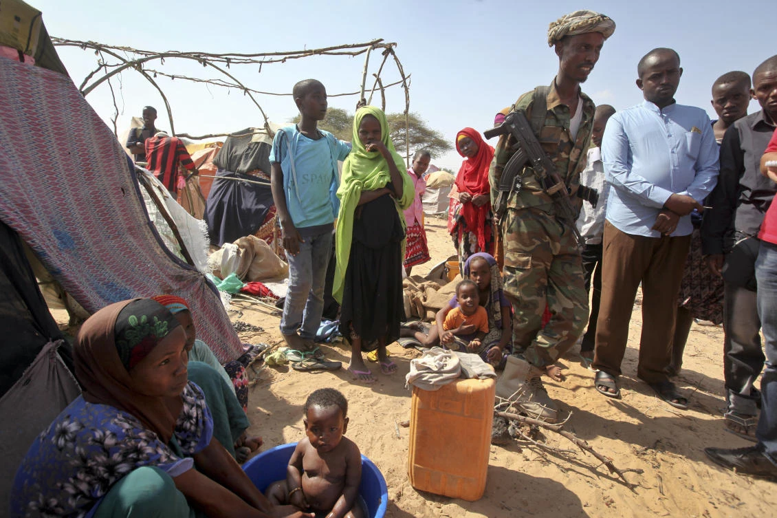A Somali soldier provides security as newly displaced Somalis gather at a camp in the Garasbaley area on the outskirts of Mogadishu, Somalia. (AP)