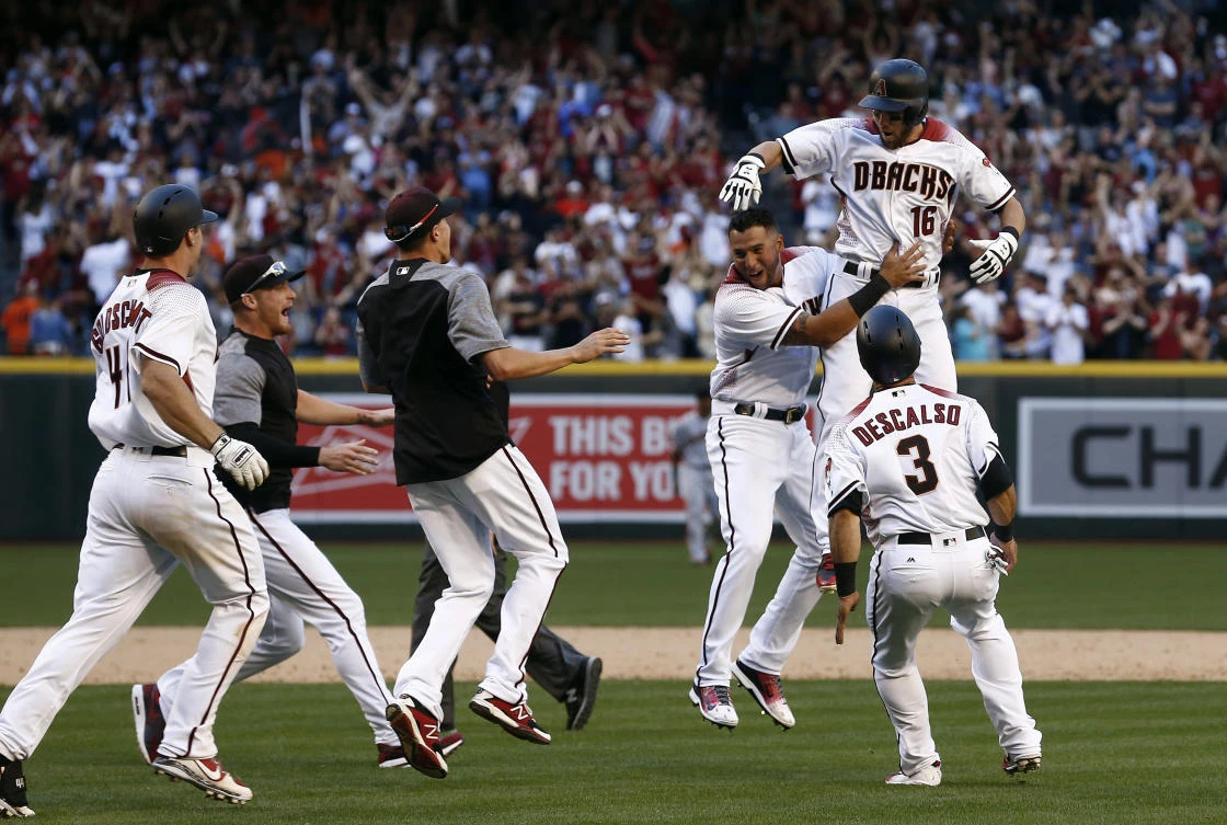Arizona Diamondbacks' Chris Owings (16) celebrates his winning hit against the San Francisco Giants with Daniel Descalso (3), David Peralta, third from right, and other teammates after an Opening Day baseball game Sunday in Phoenix. (AP)