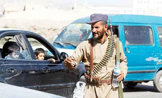 A Shi'ite militant mans a checkpoint during fighting between Shi'ite Houthi militants and government forces in Sanaa, in this September 20, 2014 file photo. (Reuters)