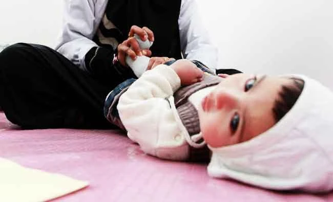 A disabled Yemeni child is helped by a physiotherapist to do physical training at a clinic for prosthetic limbs, in this February 20, 2016 file photo, in the capital Sanaa. (AFP)