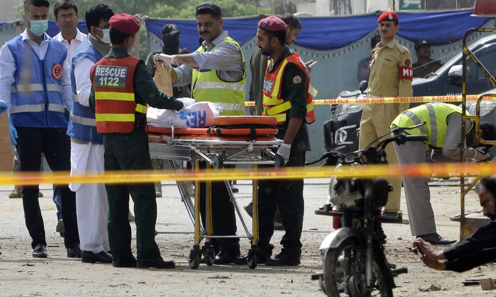 Pakistani security officials collect evidence from the scene of a suicide bomb attack on a census team in Lahore on Wednesday. (AFP / ARIF ALI)