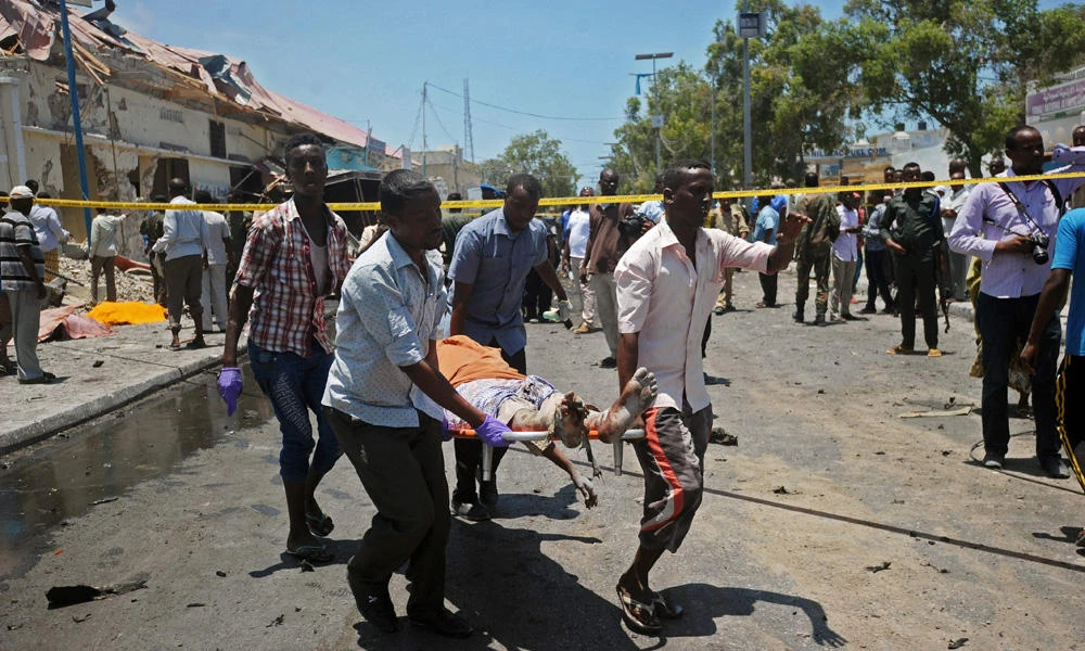 Men carry a victim in a stretcher from the scene of a car bomb attack on a restaurant in Somali capital Mogadishu on Wednesday. (AFP / MOHAMED ABDIWAHAB)