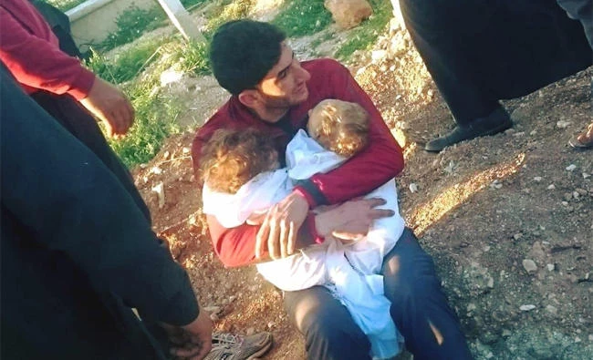 Abdel Hameed al-Youssef holds his twins who were killed in an Assad gas attack. (AP)