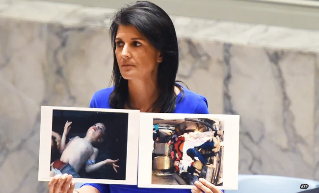 US Ambassador to the UN, Nikki Haley holds photos of victims as she speaks as the UN Security Council meets in an emergency session at the UN. (AFP)