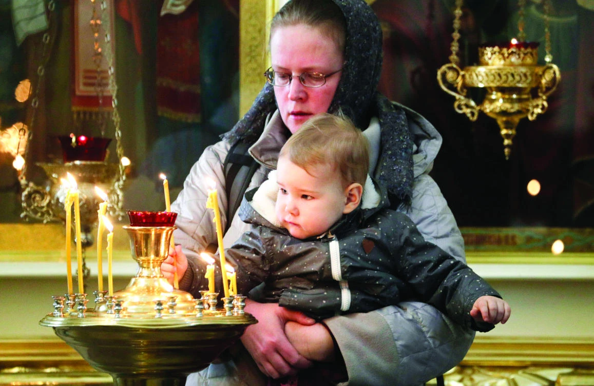 A child puts a candle during a religious service for victims of a subway explosion in a cathedral in St.Petersburg on Wednesday. (AP)