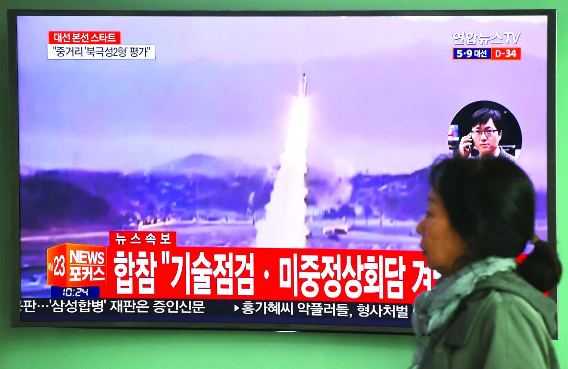 A woman walks past a television screen showing file footage of a North Korean missile launch, at a railway station in Seoul on Wednesday. (AFP)