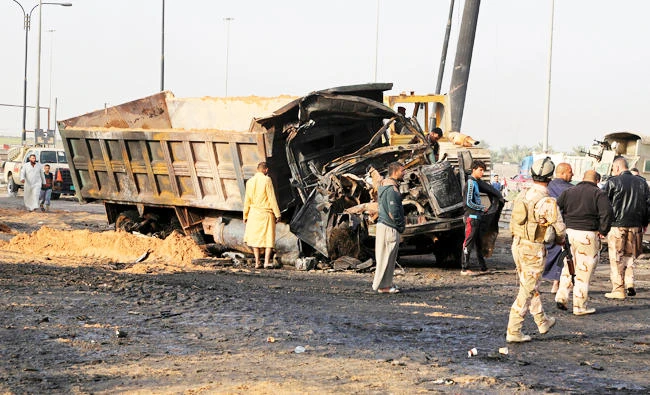 Iraqi security forces and civilians inspect the aftermath of a deadly suicide bombing in southern Baghdad, Iraq, in this photo taken on March 30, 2017. (AP)