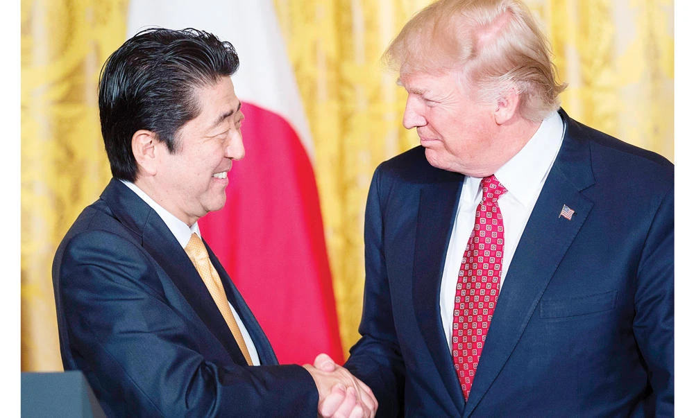 Japan’s Prime Minister Shinzo Abe, left, and US President Donald Trump shaking hands after a press conference in the East Room of the White House in Washington in this February file photo. (AFP)