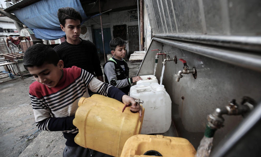 Palestinian youths filling bottles and jerricans with drinking water from public taps at the Rafah refugee camp in the southern Gaza Strip on Feb. 27, 2017. More and more Gazans are falling ill from their drinking water, highlighting the humanitarian issues facing the Palestinian enclave that the UN says could become uninhabitable by 2020. (AFP / SAID KHATIB)