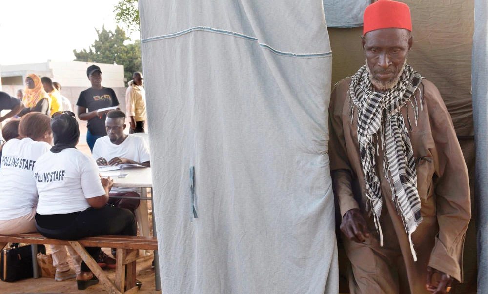 A voter leaves a polling booth in Bakau on Thursday. (AFP)
