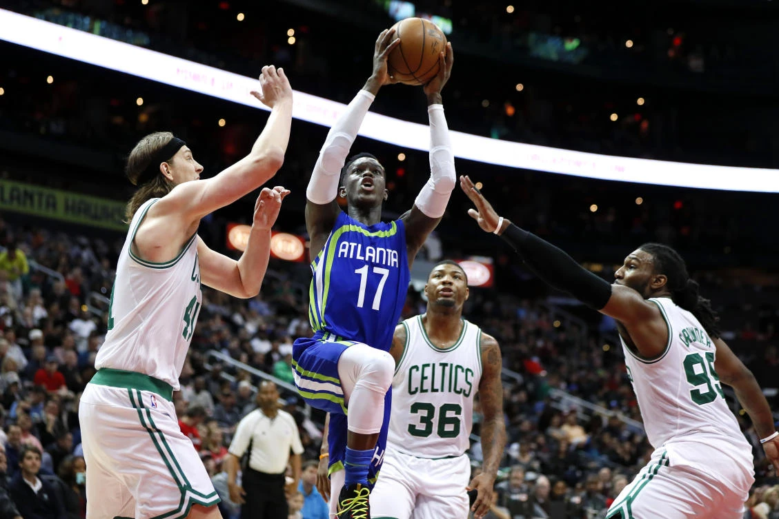 Atlanta Hawks guard Dennis Schroder (17) drives tot he basket to shoot as Boston Celtics center Kelly Olynyk (41) and forward Jae Crowder (99) defend in the second half of their NBA game in Atlanta on Thursday. (AP)