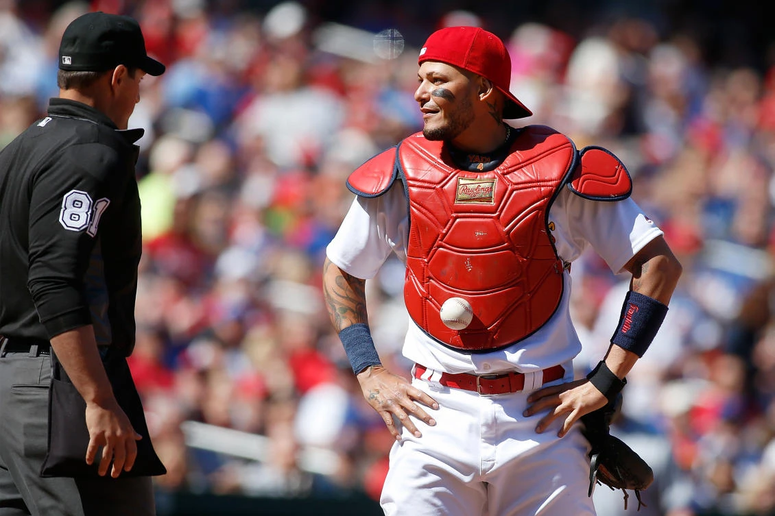 Umpire Quinn Wolcott (81) looks at a baseball that is stuck on the chest protector of St. Louis Cardinals catcher Yadier Molina (4) during the seventh inning against the Chicago Cubs at Busch Stadium on Thursday night. (USA TODAY Sports)